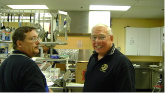 Two Pancake Day volunteers in a kitchen in 2009