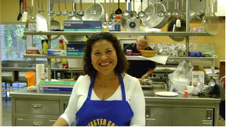 Pancake Day volunteer smiling in a kitchen in 2009