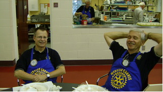 Two Pancake Day volunteers seated at a table in 2009