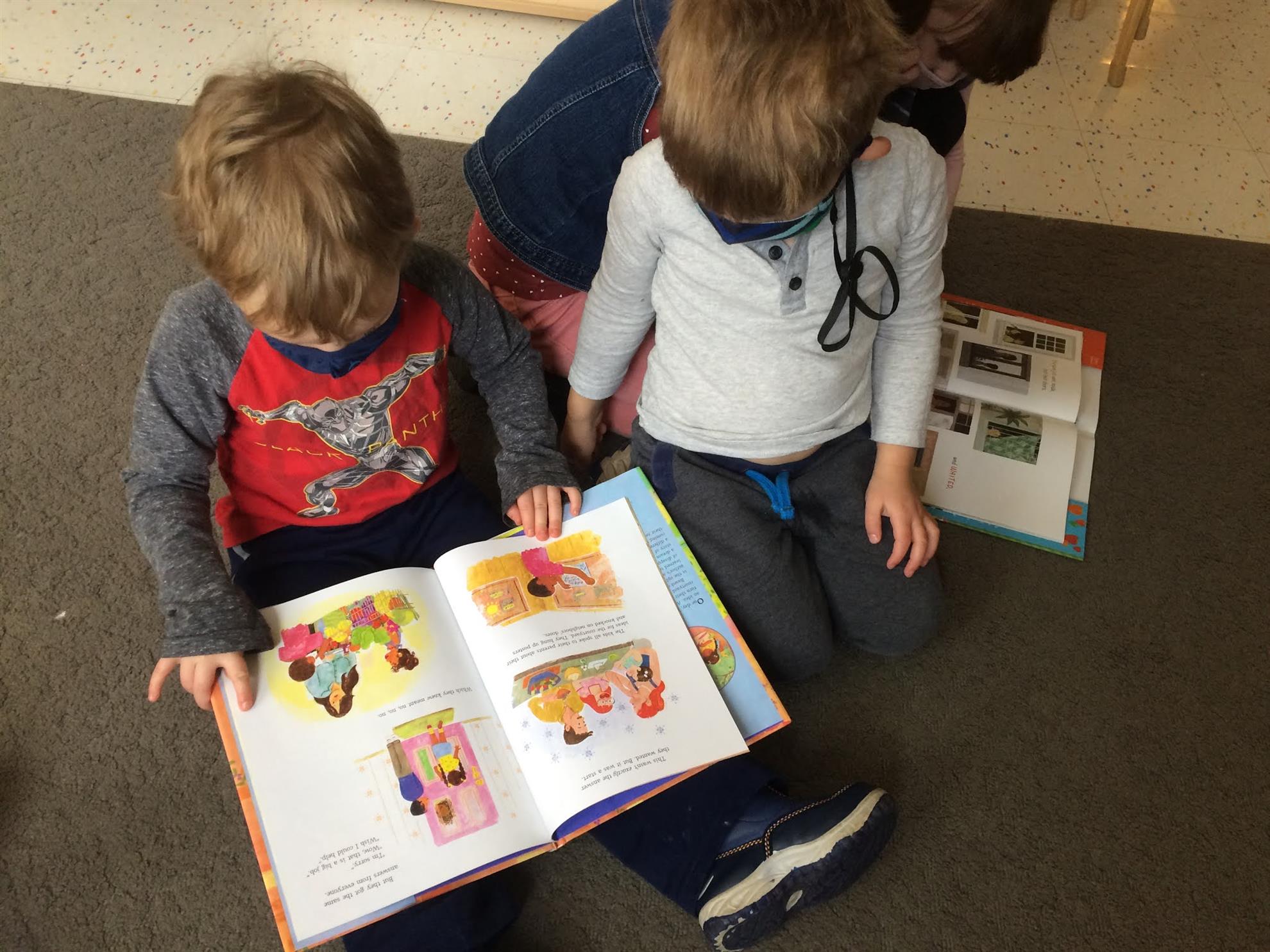 Three children reading a picture book together