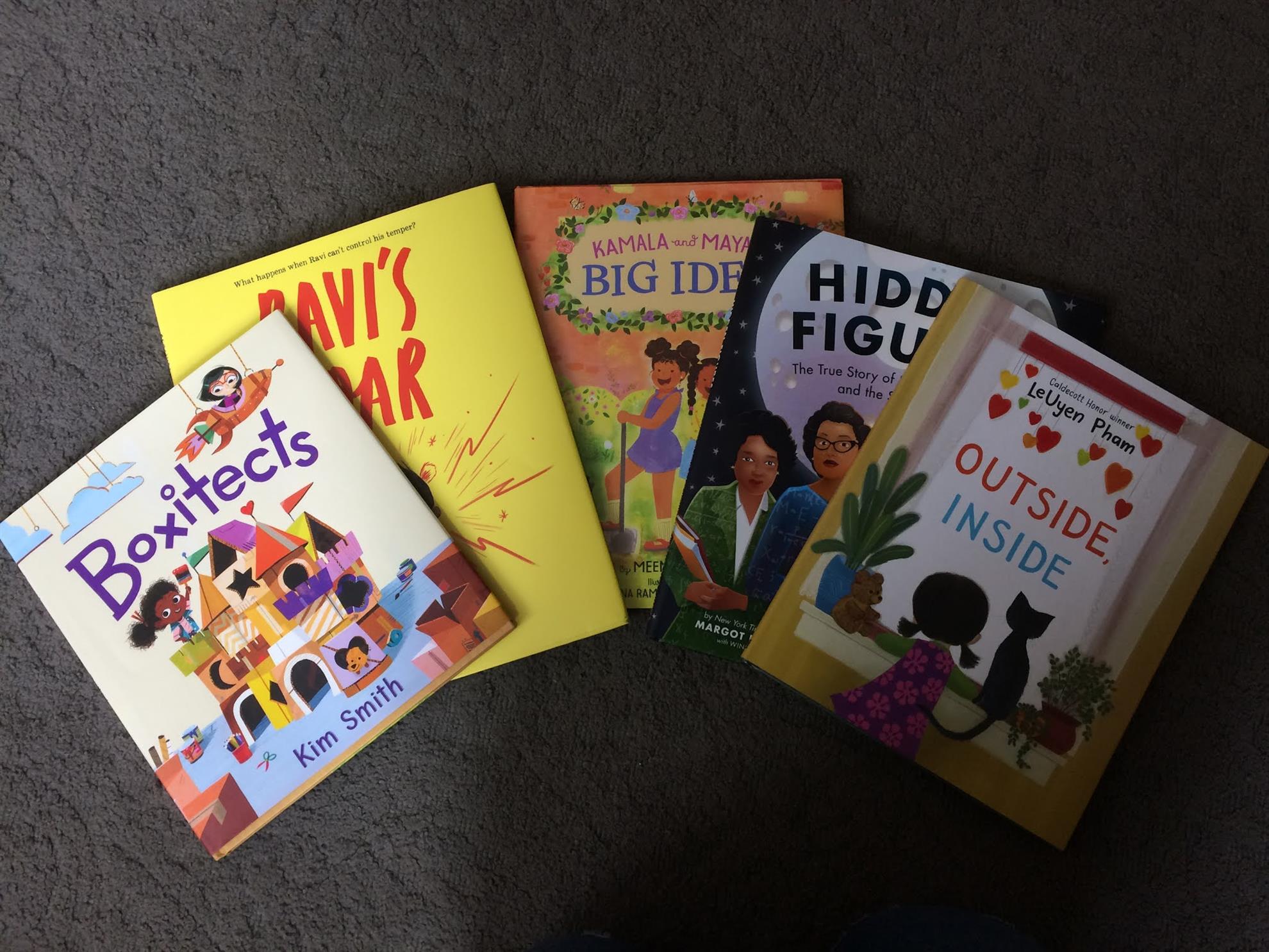 Five children’s books arranged on a carpet