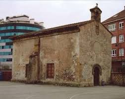 Exterior of the weathered stone San Esteban del Mar chapel in Gijón, Spain